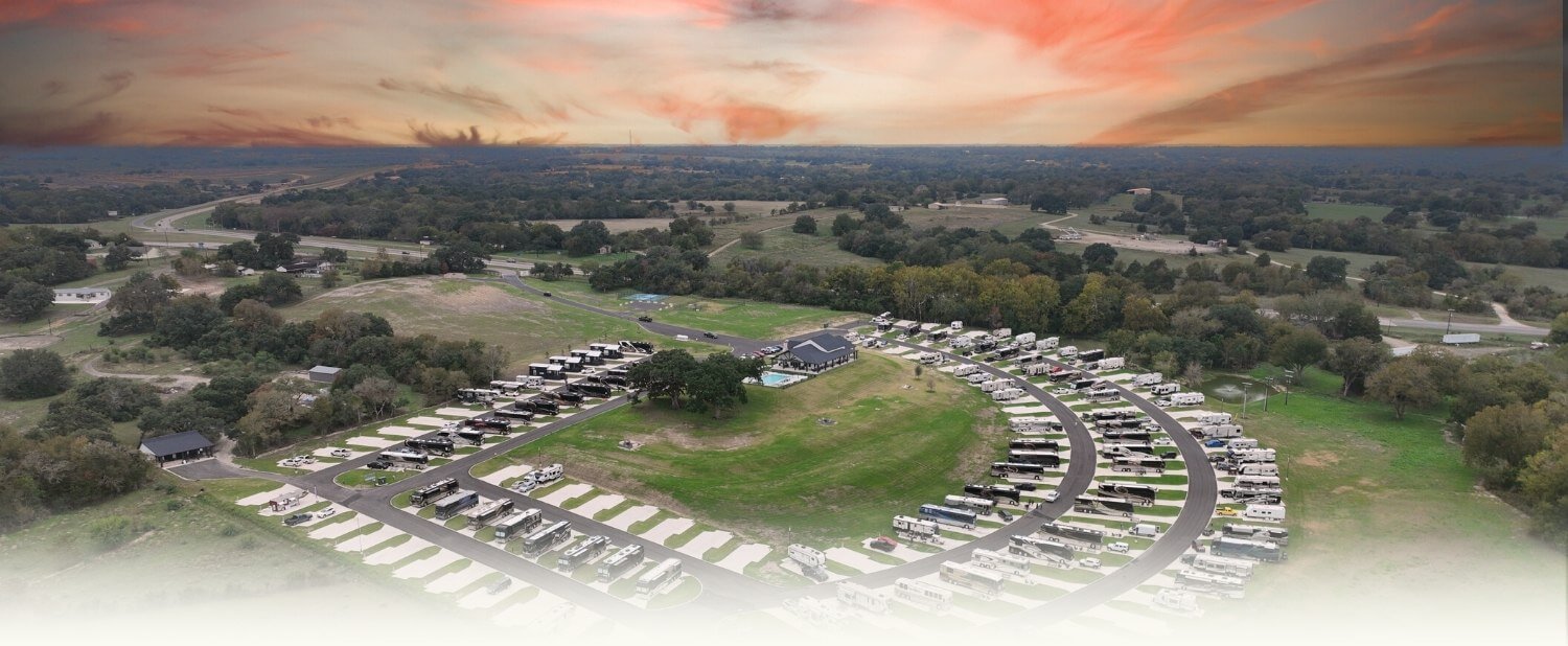 An overview of The Hill Top at Brenham at sunset with trees and houses in the background